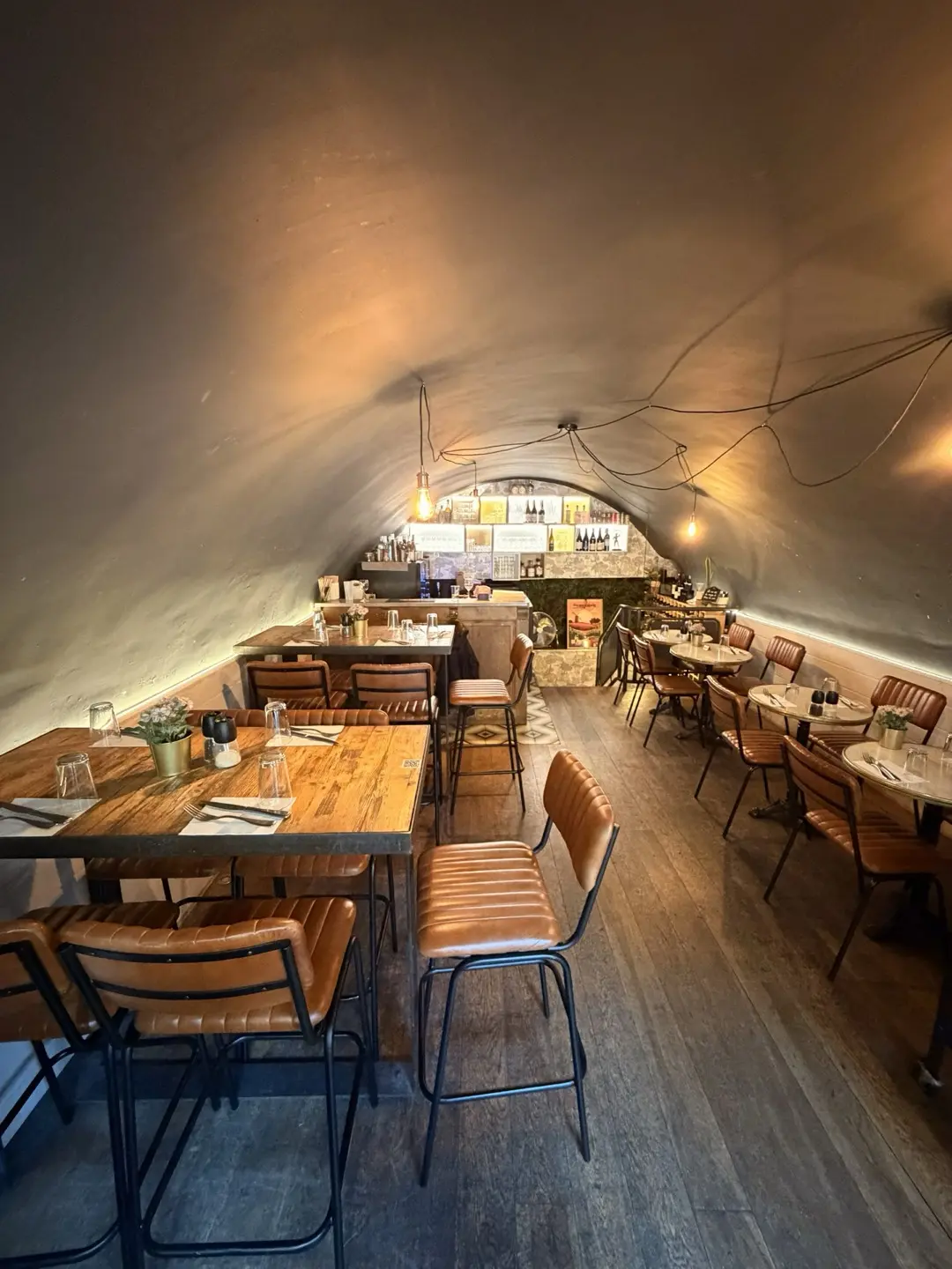 Intérieur voûté du Vieux Tonneau : pierre, chandeliers et banquettes, bar à vins à Aix-en-Provence